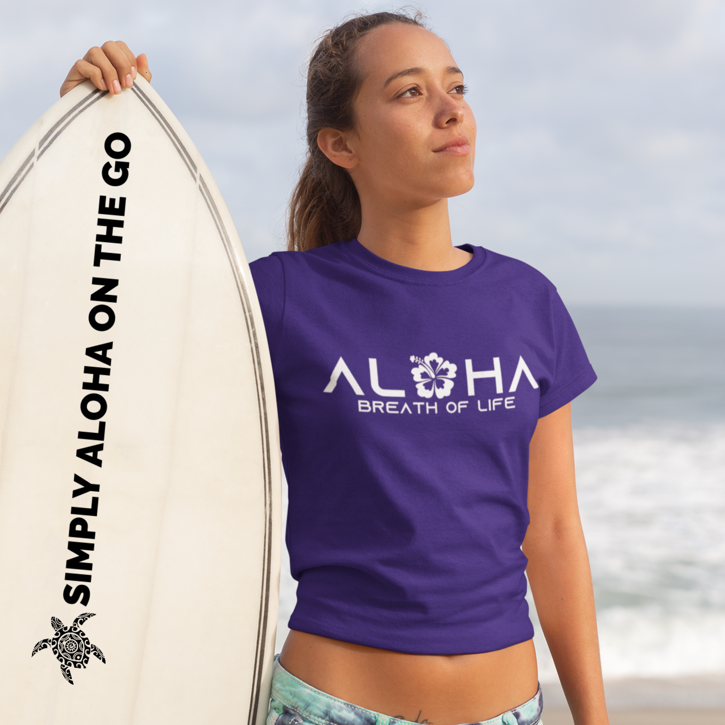 A woman wearing an "Aloha Breath of Life" t-shirt with a hibiscus design, an island-inspired shirt.