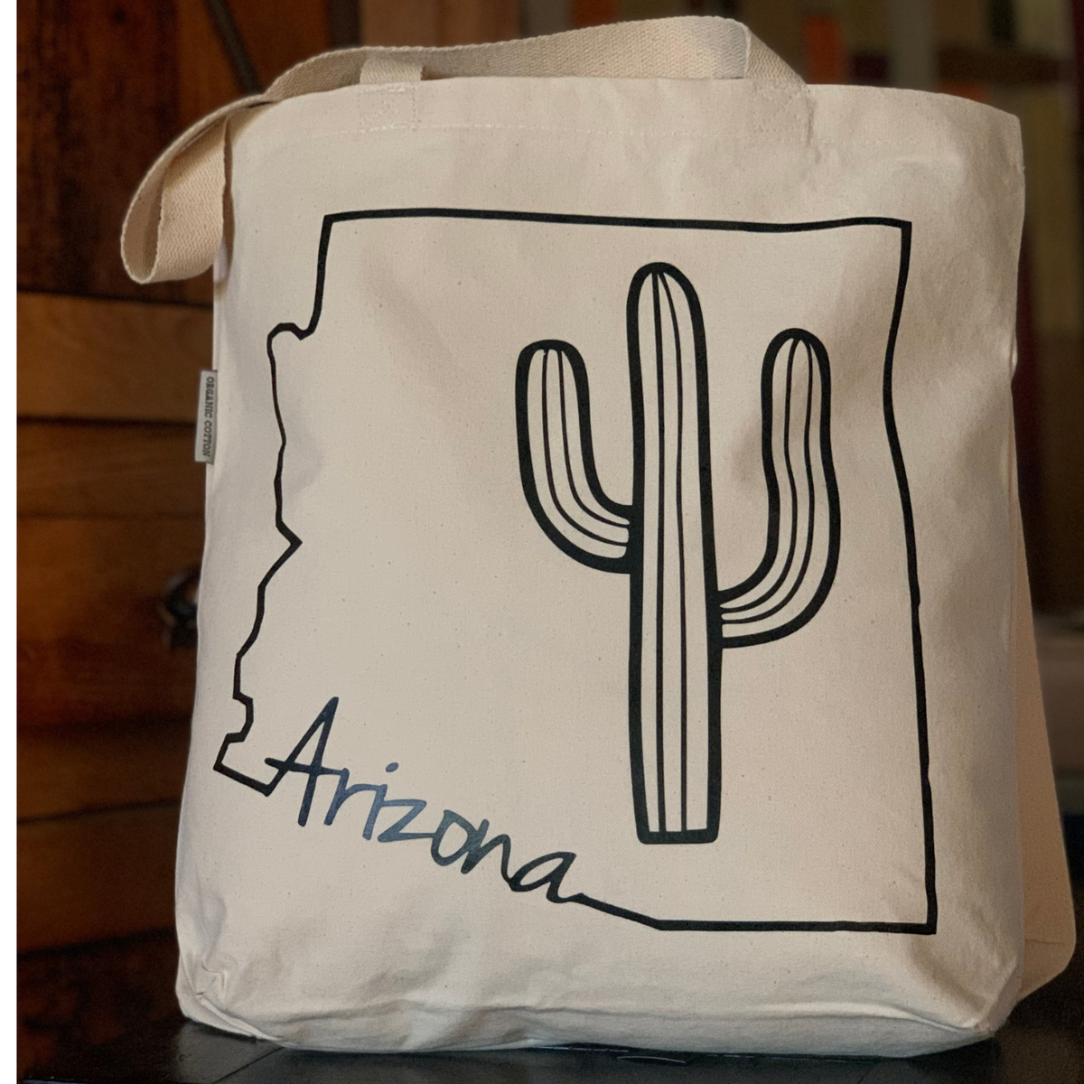 The Arizona Cactus Tote Bag for shopping, farmer's market, library run and everyday errands, sitting at a diplay table.
