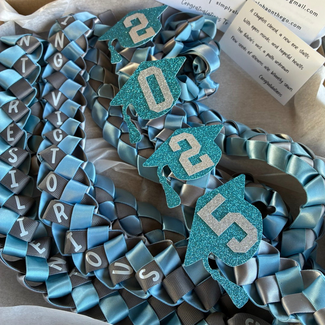 Close-up of a personalized Island-Style Graduation Ribbon Lei in three school colors, showing the intricate hand-stitched satin and the graduate’s name in vinyl and cardstock.