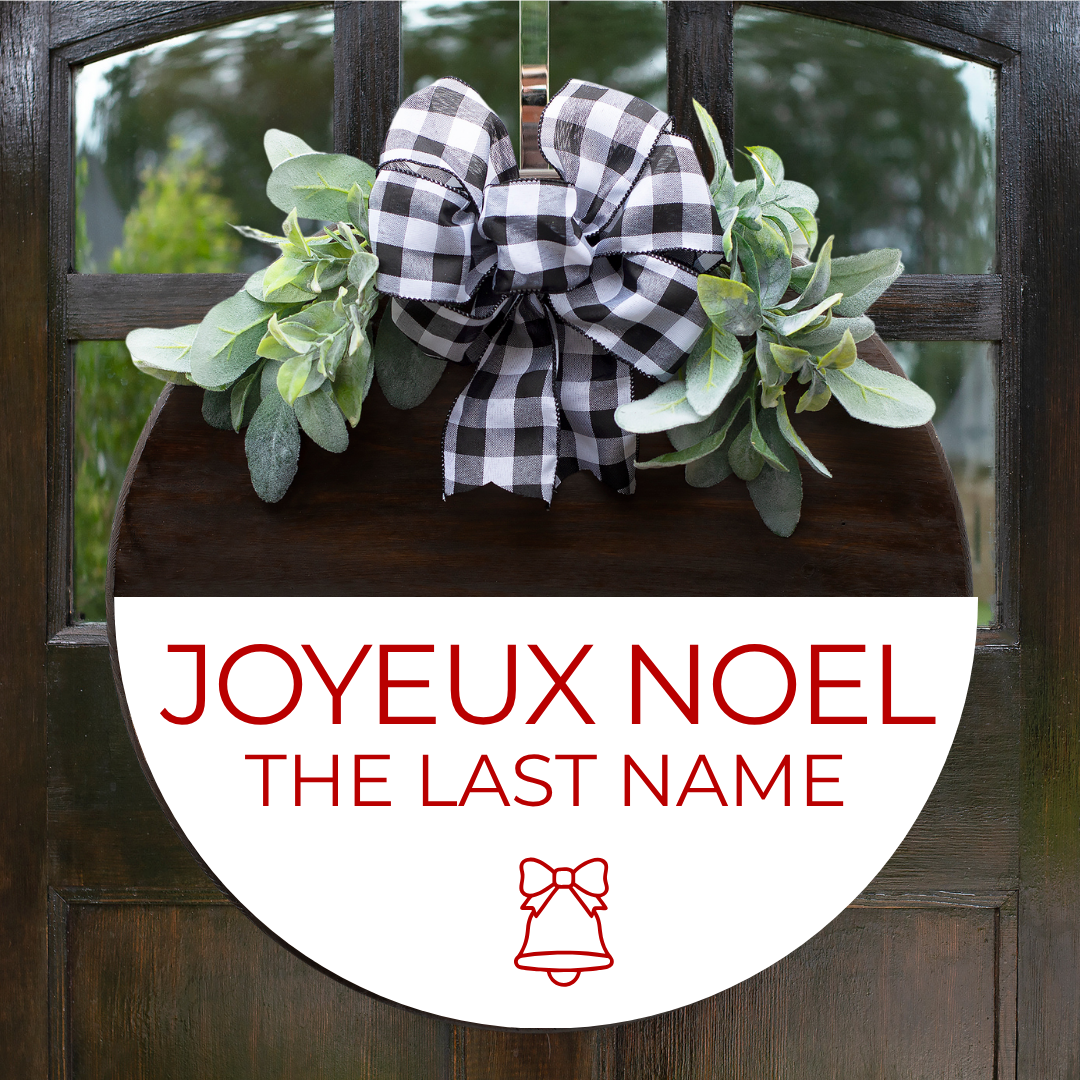 French Christmas door hanger featuring Joyeux Noël personalized with family name in red lettering, with buffalo plaid bow and greenery