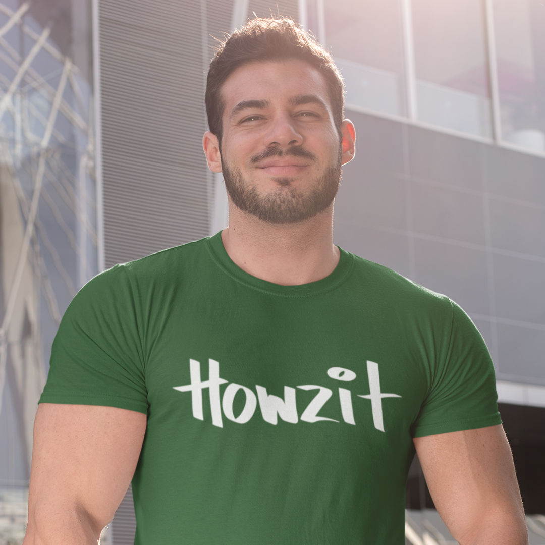 A man wearing a green men's t-shirt that says "Howzit" in a simple white font, a Hawaiian slang shirt. Available in different sizes and colors.
