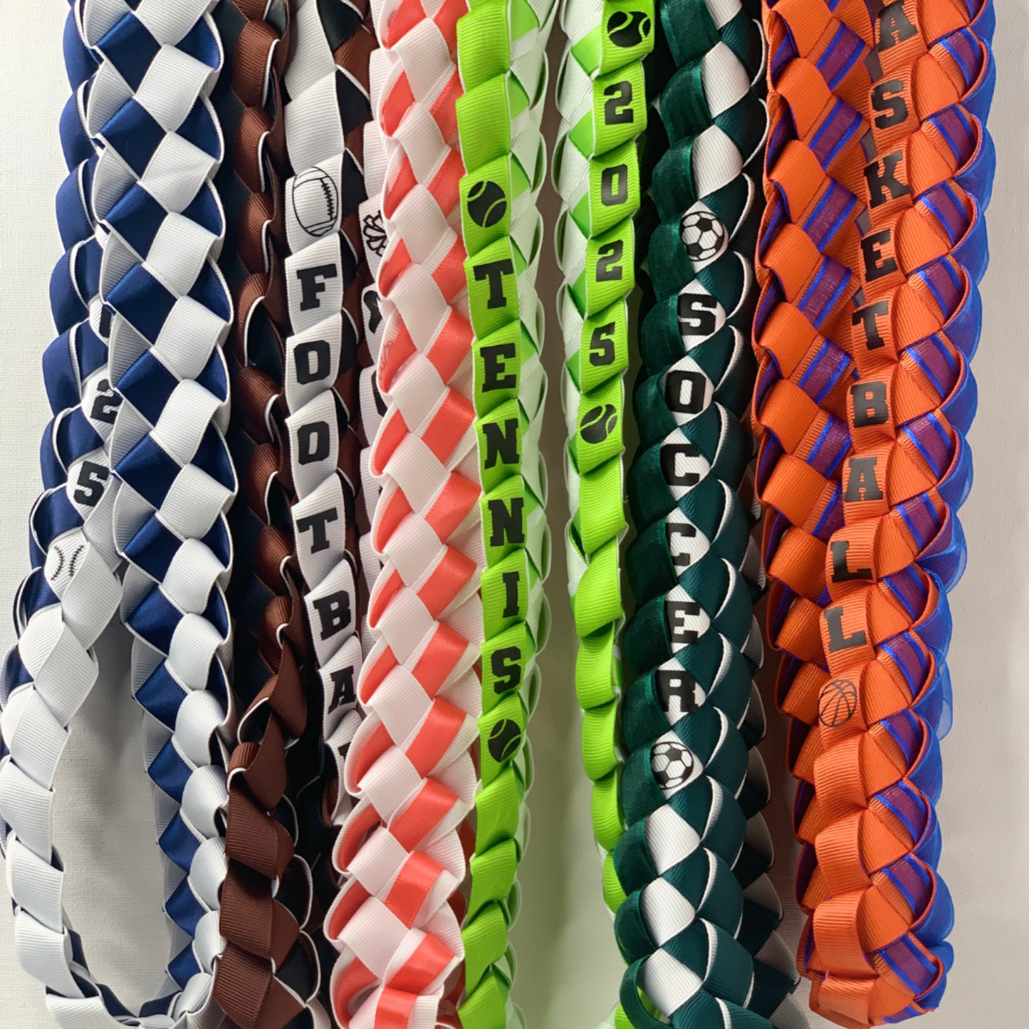 Custom closeup of sports senior night ribbon leis, personalized with athlete's name and jersey number