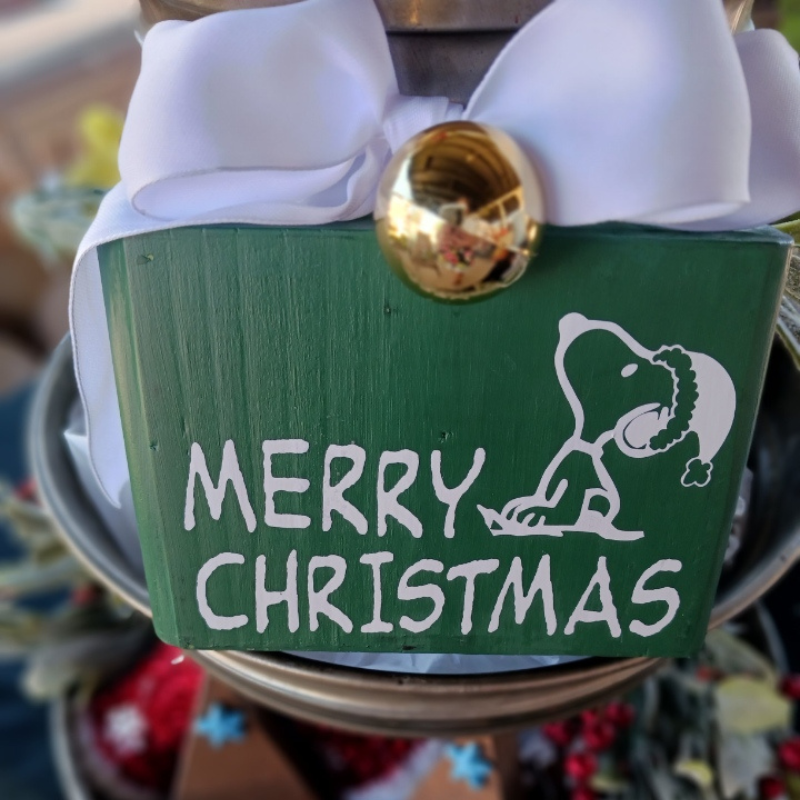Double-sided 3.75x5 mini sign featuring Snoopy with “Merry Christmas” on one side and a snowflake wood photo holder on the back front side with a snowflke topped with a gold ornament and white ribbon design perfect for holiday