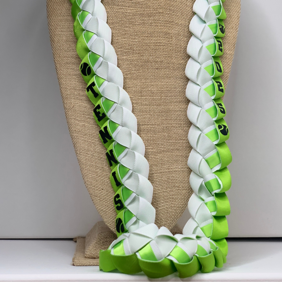Close Up Custom Tennis Ribbon Lei in green and white school colors for tennis players, Senior Night and graduation gifts.