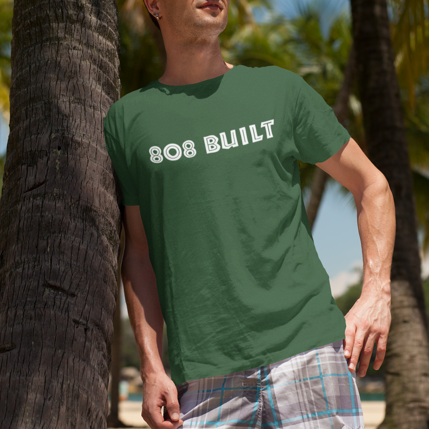 Man wearing the 808 Built Hawaii T-Shirt, which features a double-sided graphic print for local pride, styled for casual wear.
