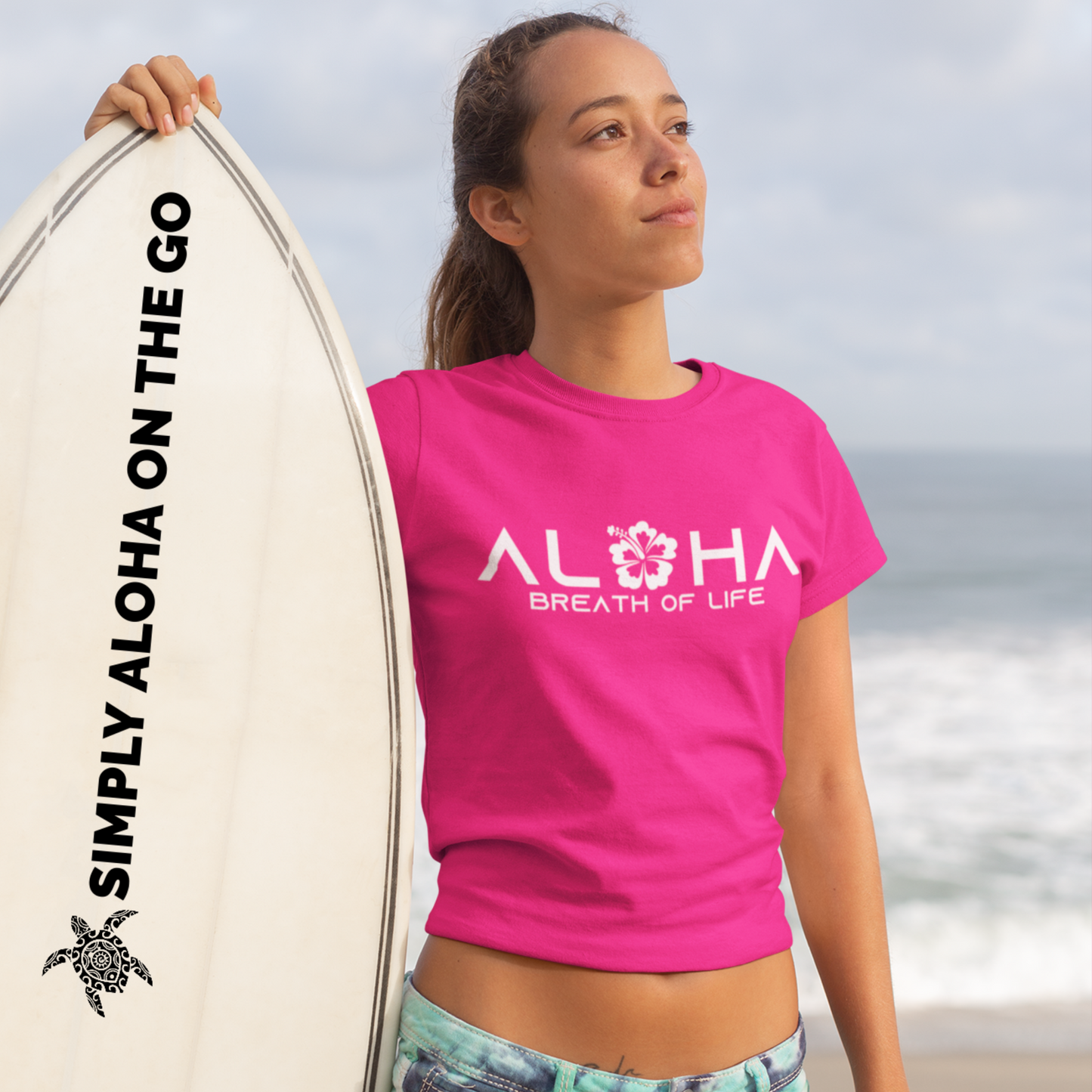 A woman wearing an "Aloha Breath of Life" t-shirt with a hibiscus design, an island-inspired shirt.