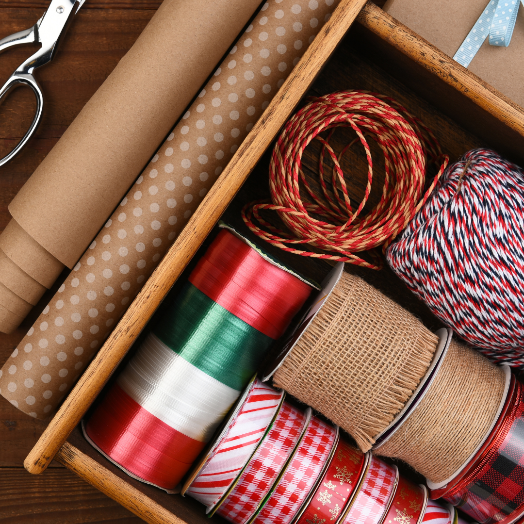 Assorted ribbons and paper in a wooden box on a wooden surface