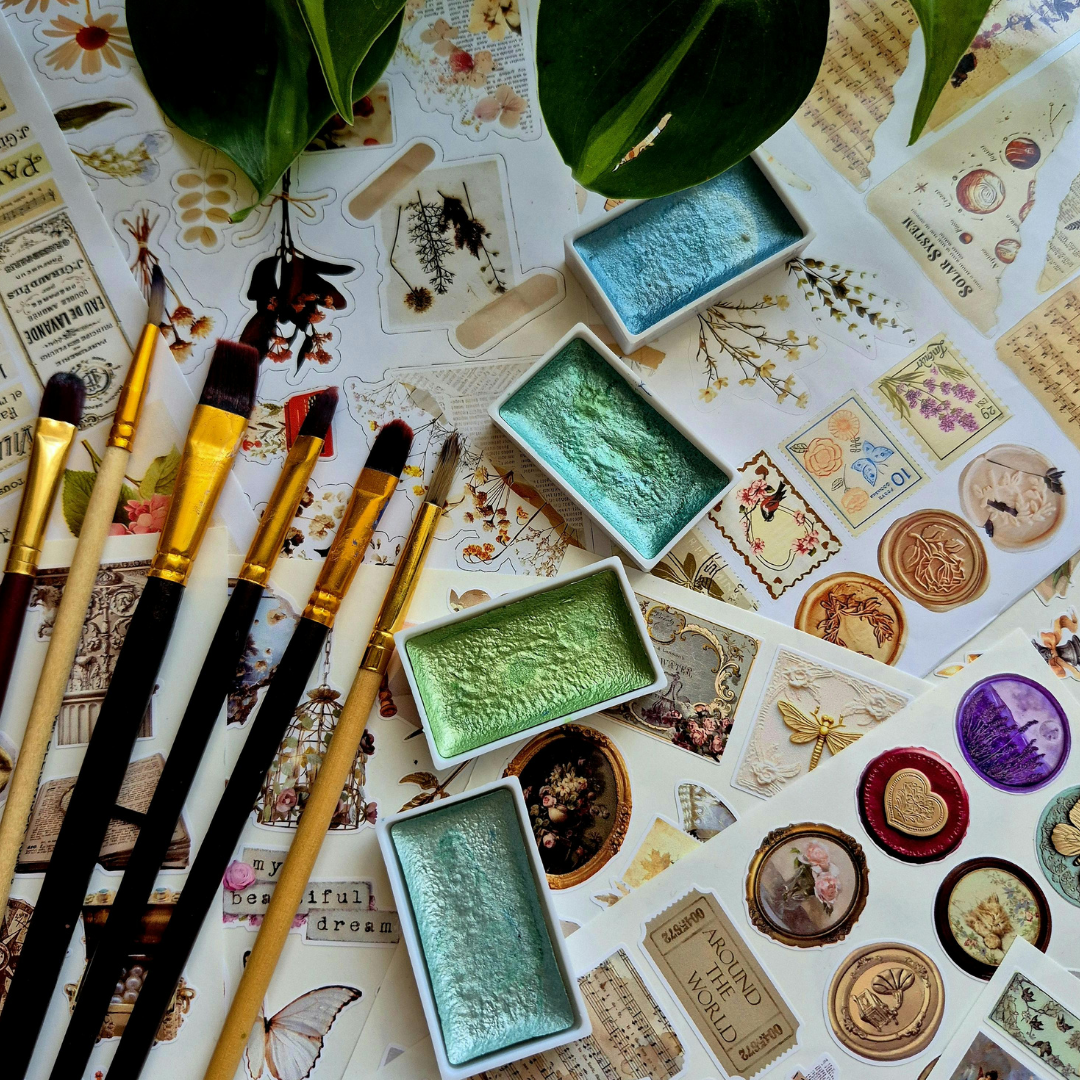 Art supplies including paintbrushes and color swatches on a decorative surface with vintage-style designs.