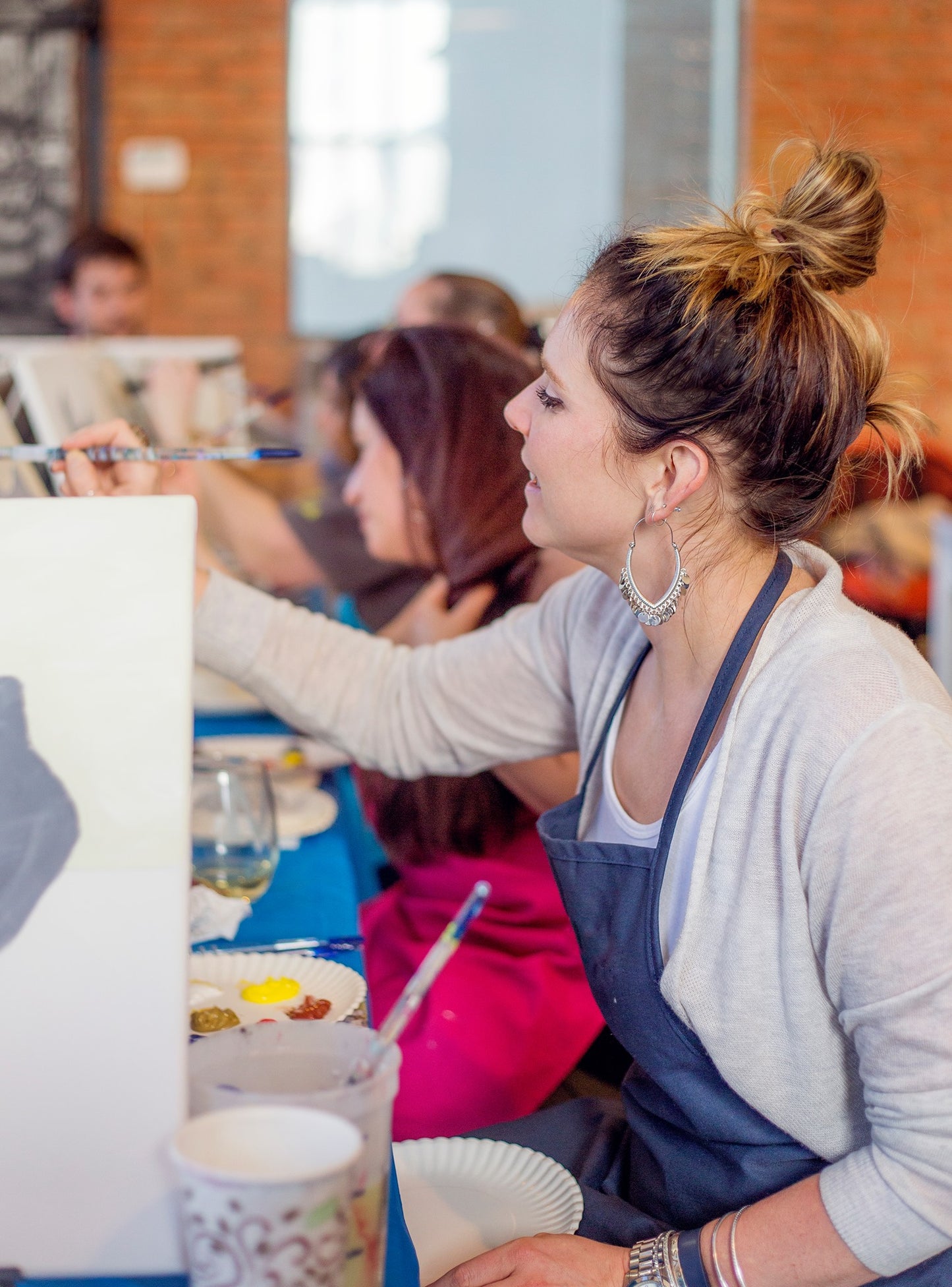 An artist teaching at a Simply Aloha On The Go mobile paint party, showcasing the interactive on-site experience available statewide in Arizona.