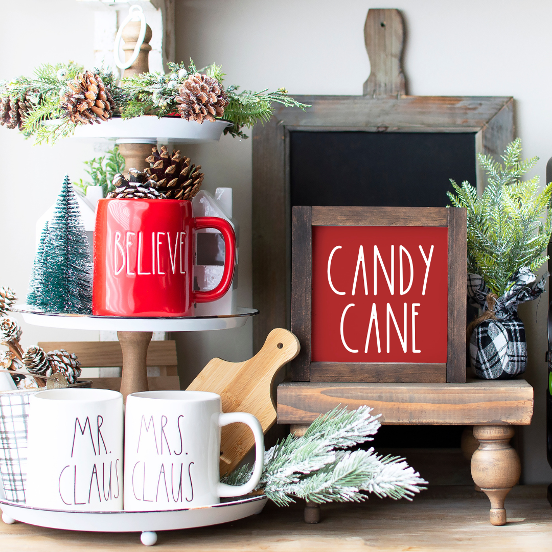 Handcrafted 6x6 rustic wood framed Candy Cane sign styled on a Christmas tiered tray on ared background.