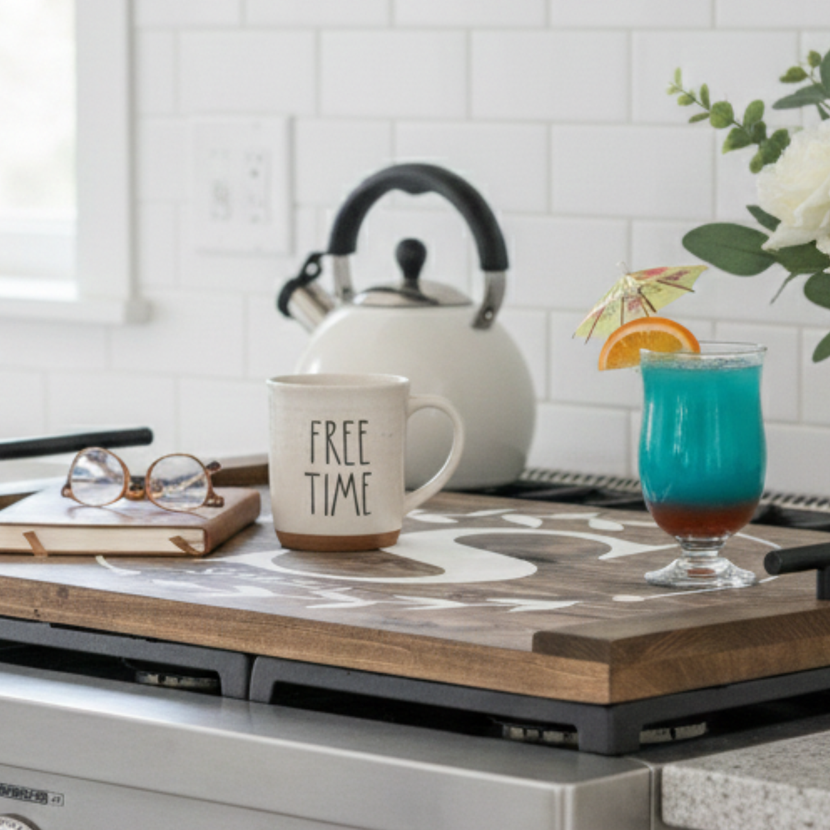 Monogram wreath noodle board in dark walnut with white floral wreath, custom family initial and last name, and black decorative handles on top of a stove.