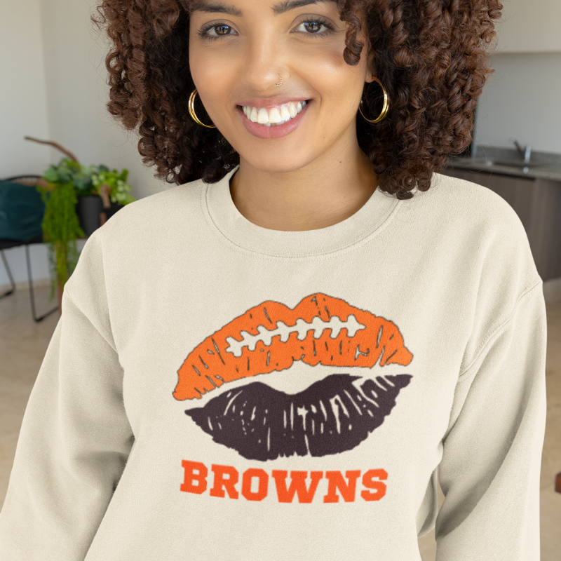 Close-up of sand colored lip-themed sweatshirt showing the unique personalized team colors graphic detail.