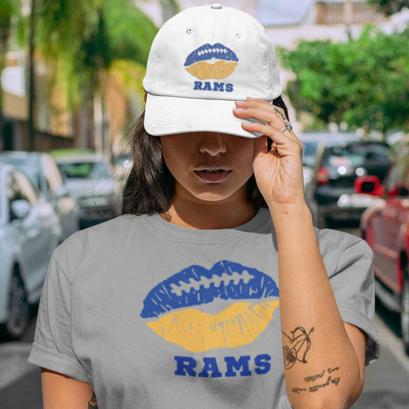 A woman wearing game day t-shirt in grey color with a lip-themed design in blue and yellow on top and the team name written below. 