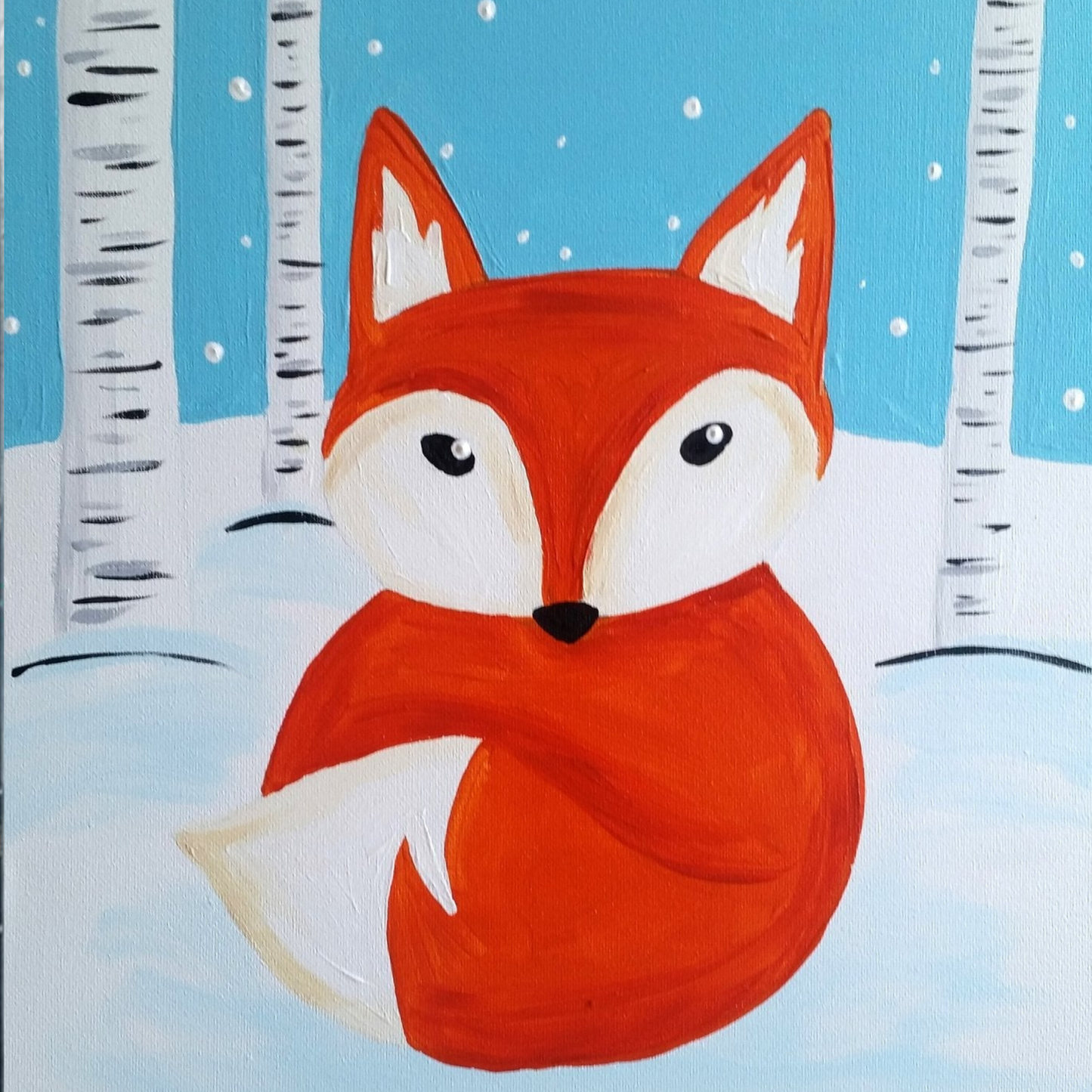 A bright orange fox sitting in white snow surrounded by birch trees under a light blue winter sky.