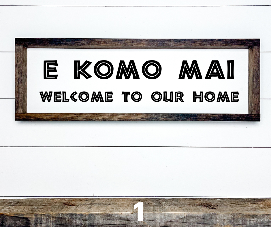 Hawaiian E Komo Mai Welcome wood sign with tropical floral accents, shown hanging on a front door for island-style entryway decor.