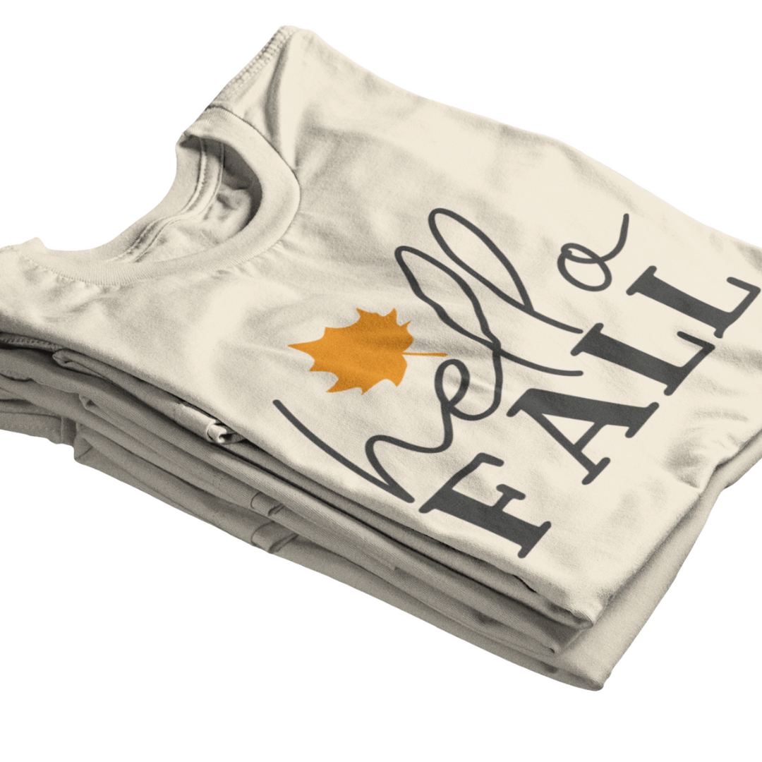 Stack of folded t-shirts with Hello Fall design on a white background