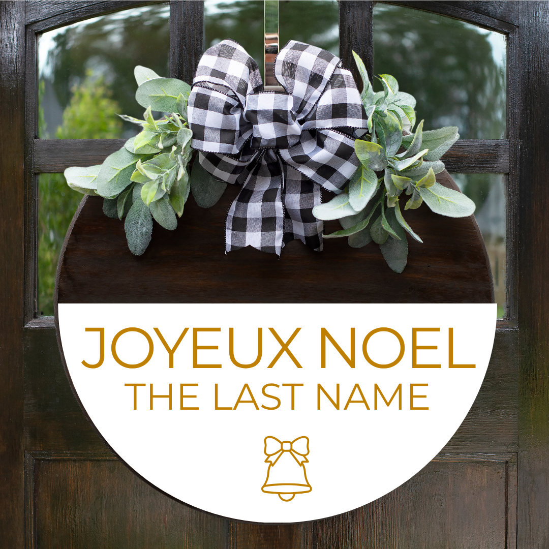 French Christmas door hanger personalized with family name in gold lettering, with buffalo plaid bow and greenery