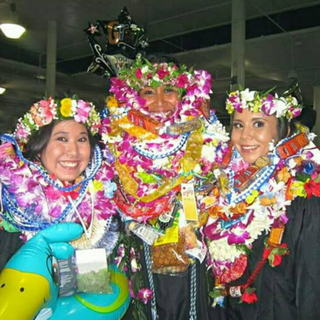 A group of 2026 grads with their island traditions on graduation day. From ribbon leis to candy leis, flower leis, toy lei and a whole lot more! It's the island-way of celebrating!