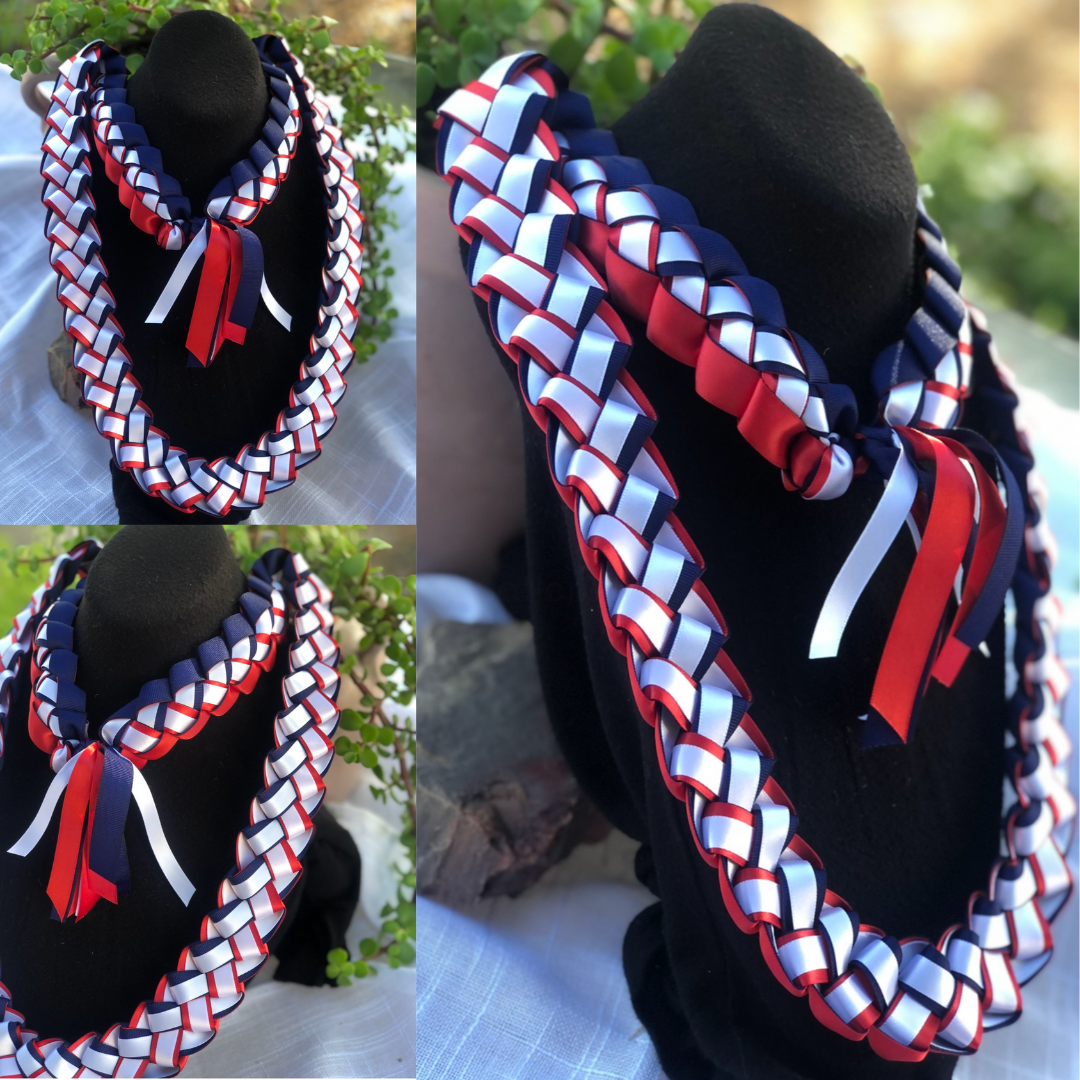 Graduation Leis 2027 collection featuring handcrafted red, white and blue braided ribbon leis displayed on black stands for graduation celebrations.
