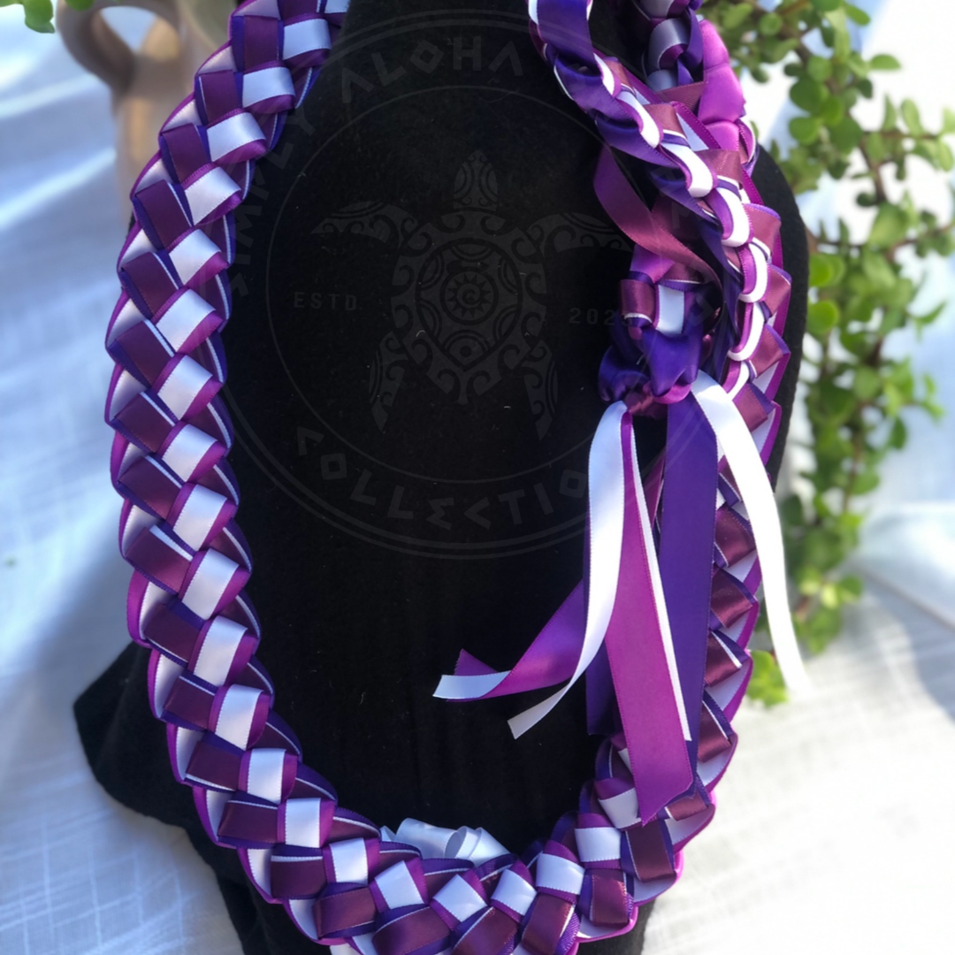 Custom graduation ribbon lei featuring purple and white braided ribbons with a matching decorative bow, displayed on a black stand.
