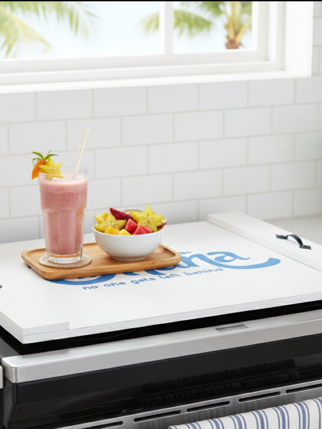 Handcrafted white wooden noodle board featuring blue 'Ohana' stenciled design on a stove top, used as a kitchen counter space saver and serving tray.