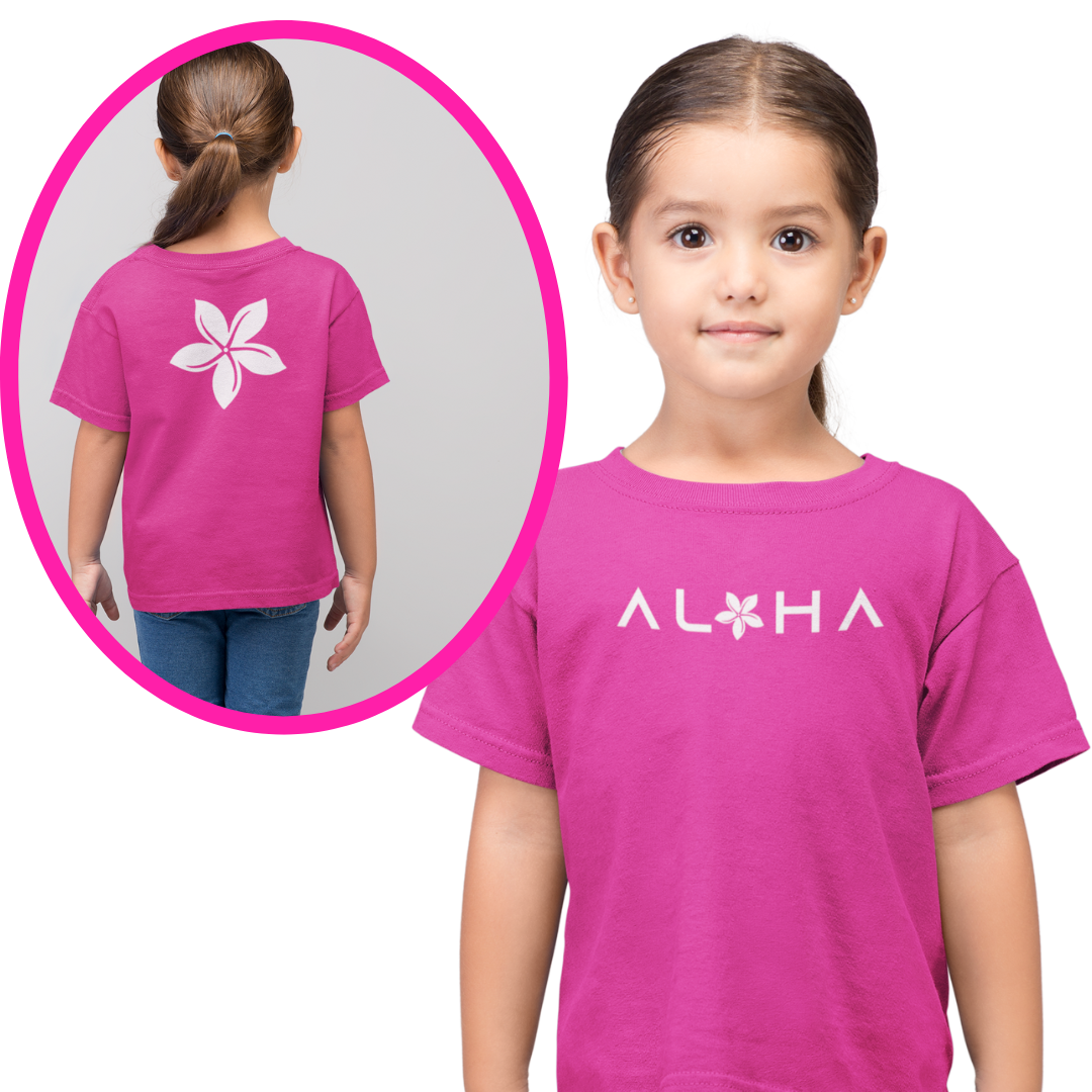 A smiling young girl wearing a bright pink custom kids t-shirt that displays a white chest graphic reading Aloha with a tiare flower.