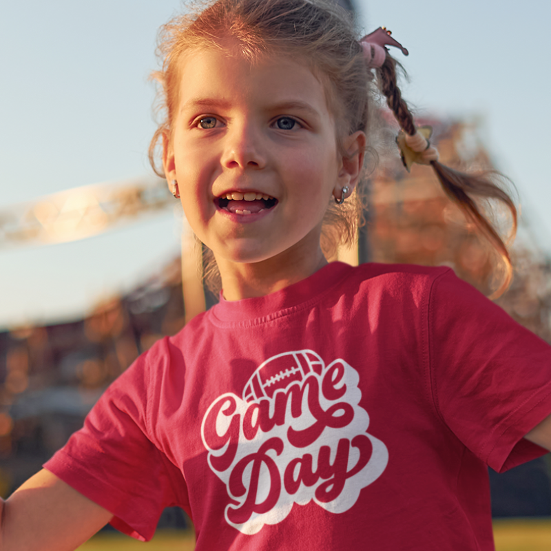 Personalized kids double-sided game day football t-shirt in pink with custom team name and number by Simply Aloha On The Go