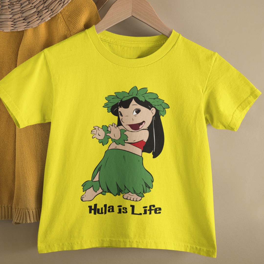A yellow kids Hawaiian t-shirt with a text reading Hula Is Life with a graphic of a girl dancing hula