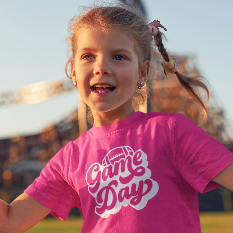 Personalized kids double-sided game day football t-shirt in pink with custom team name and number by Simply Aloha On The Go