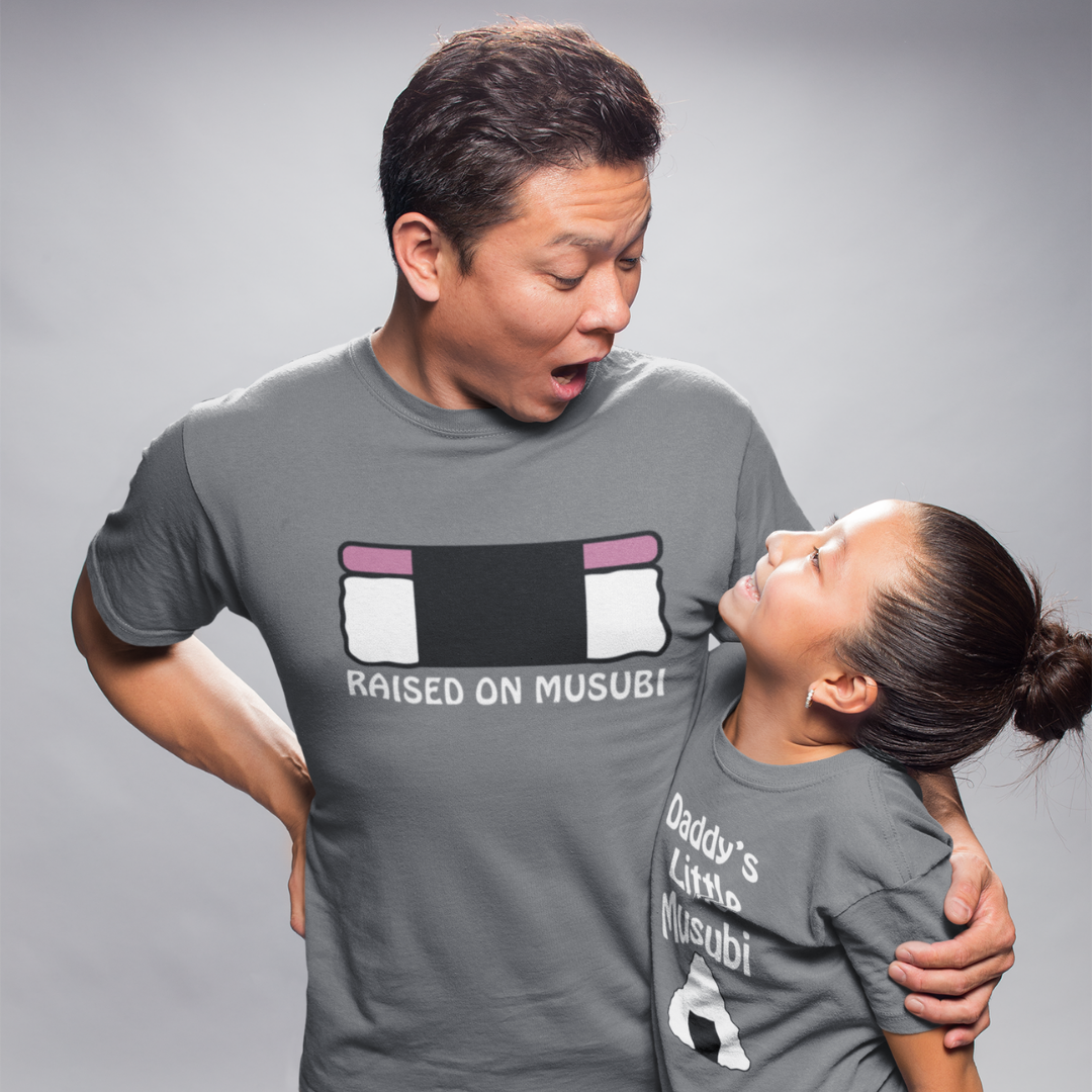 Dad and daughter in matching raised on musubi Hawaiian t-shirts in charcoal grey 