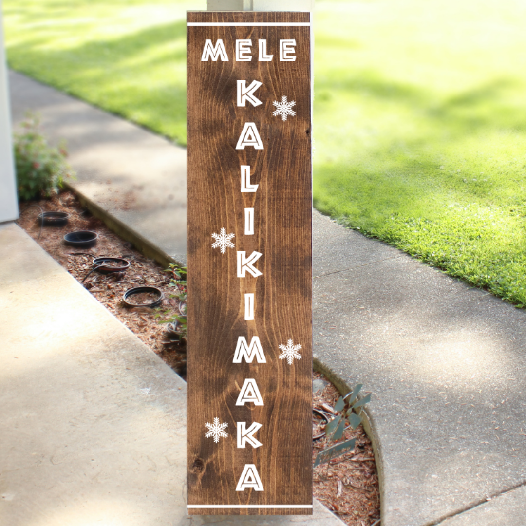 Vertical stained wood Christmas porch sign reading Mele Kalikimaka with white lettering and snowflake accents, handcrafted by Simply Aloha On The Go