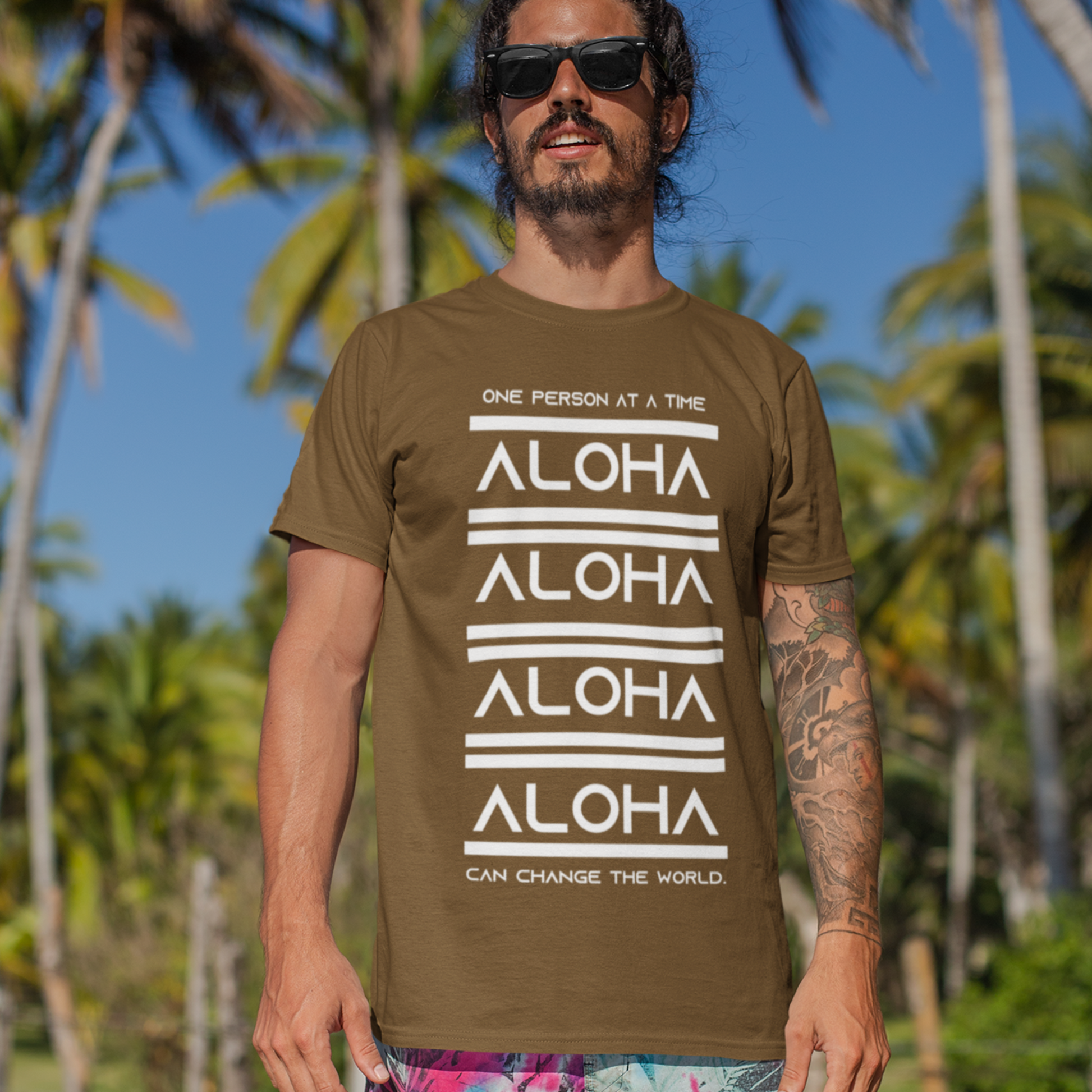 Aloha T-shirt featuring the inspirational message One Person At A Time Can Change The World. This shirt represents the Aloha spirit a perfect reminder of how small actions can make a big difference.