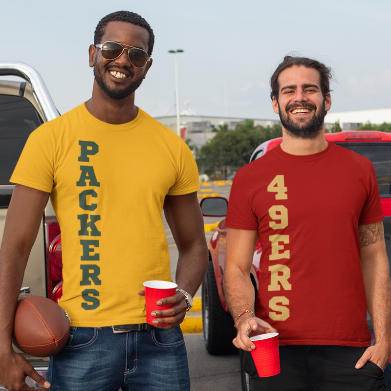 Friends at a tailgate party wearing a personalized men's game day t-shirt featuring vertical blue text reading "49ers" "PACKERS" text