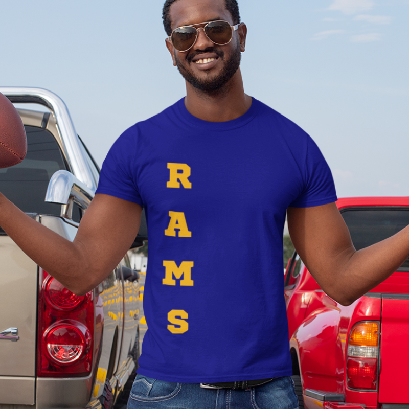 A man at a tailgate party wearing a personalized men's game day t-shirt featuring vertical yellow gold text reading "RAMS"