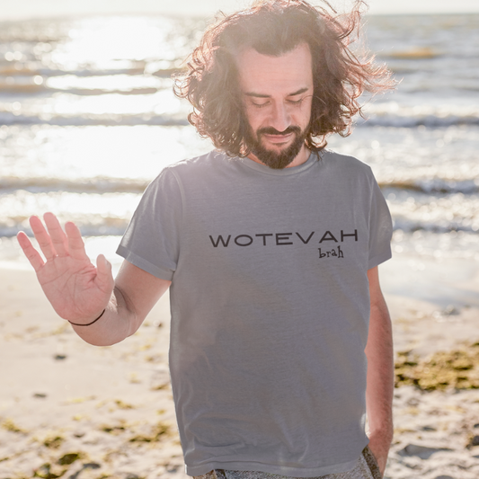 A man wearing a custom grey men's t-shirt that features minimalist black block text reading "WOTEVAH brah"