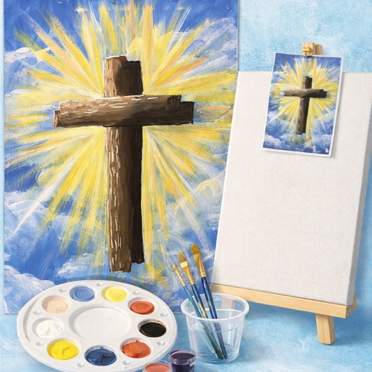 Painting of a cross with a bright yellow light on a blue background, surrounded by art supplies.
