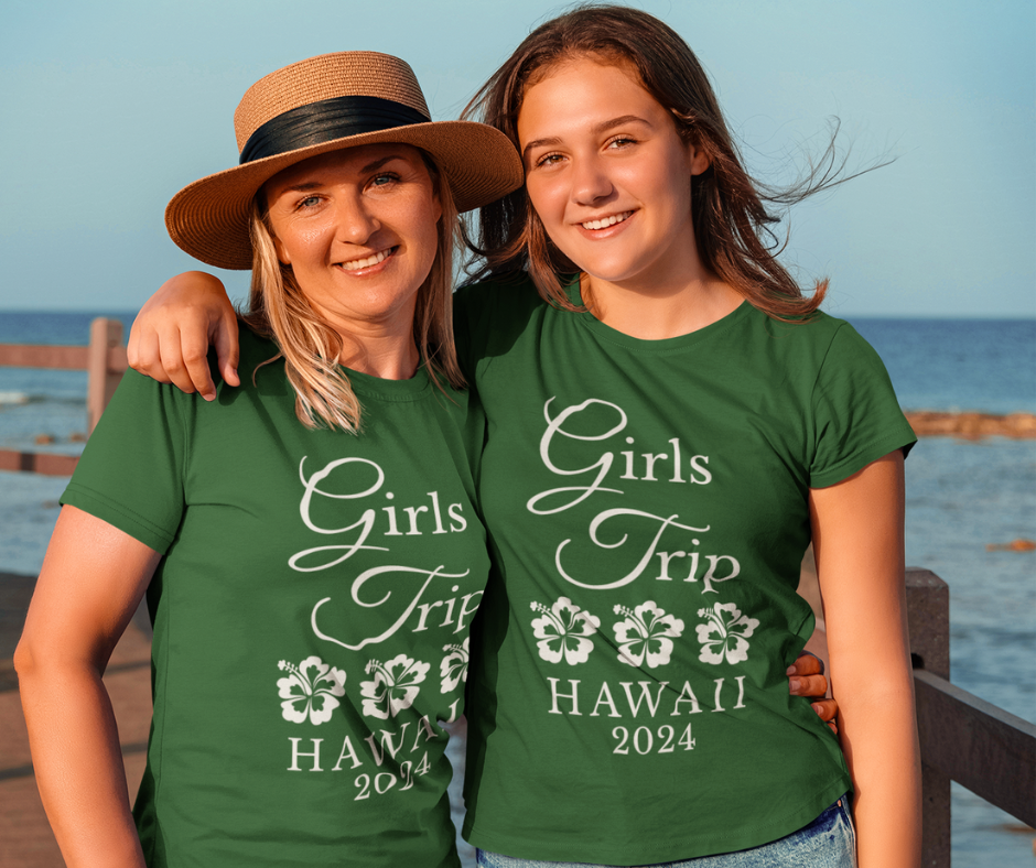 Two women wearing matching personalized "Girls Trip" t-shirts on vacation
