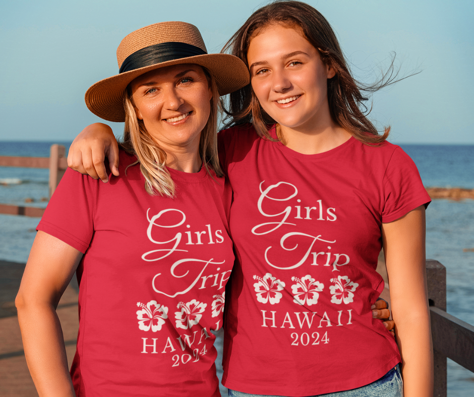 Two women wearing matching personalized "Girls Trip" t-shirts on vacation