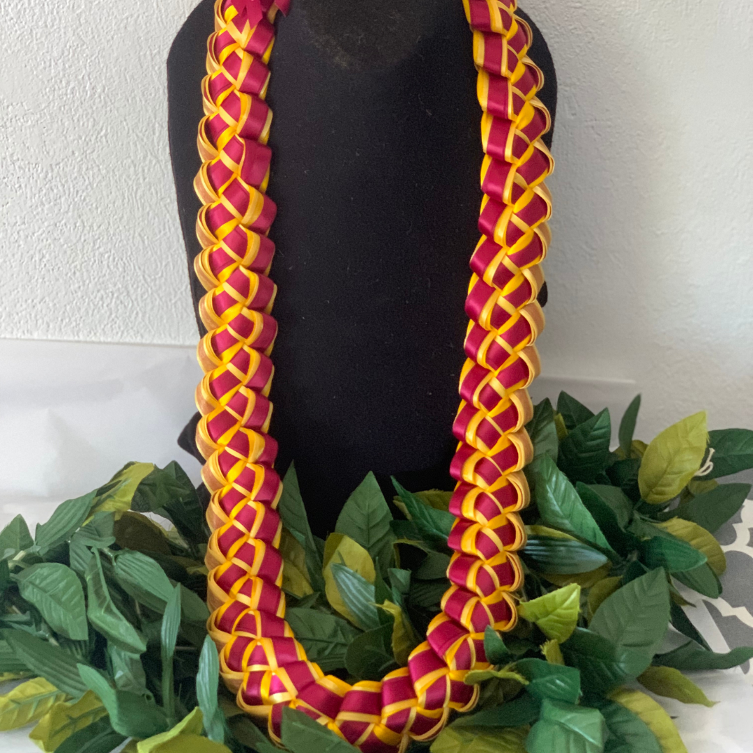 Personalized Graduation Ribbon Lei handcrafted in maroon and gold braided ribbon, displayed on a black stand for graduation ceremonies.