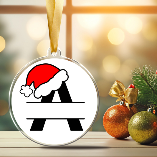 Personalized monogram Christmas ornament featuring black letter A with a red Santa hat, blank center banner for a custom name or title, and gold satin ribbon.