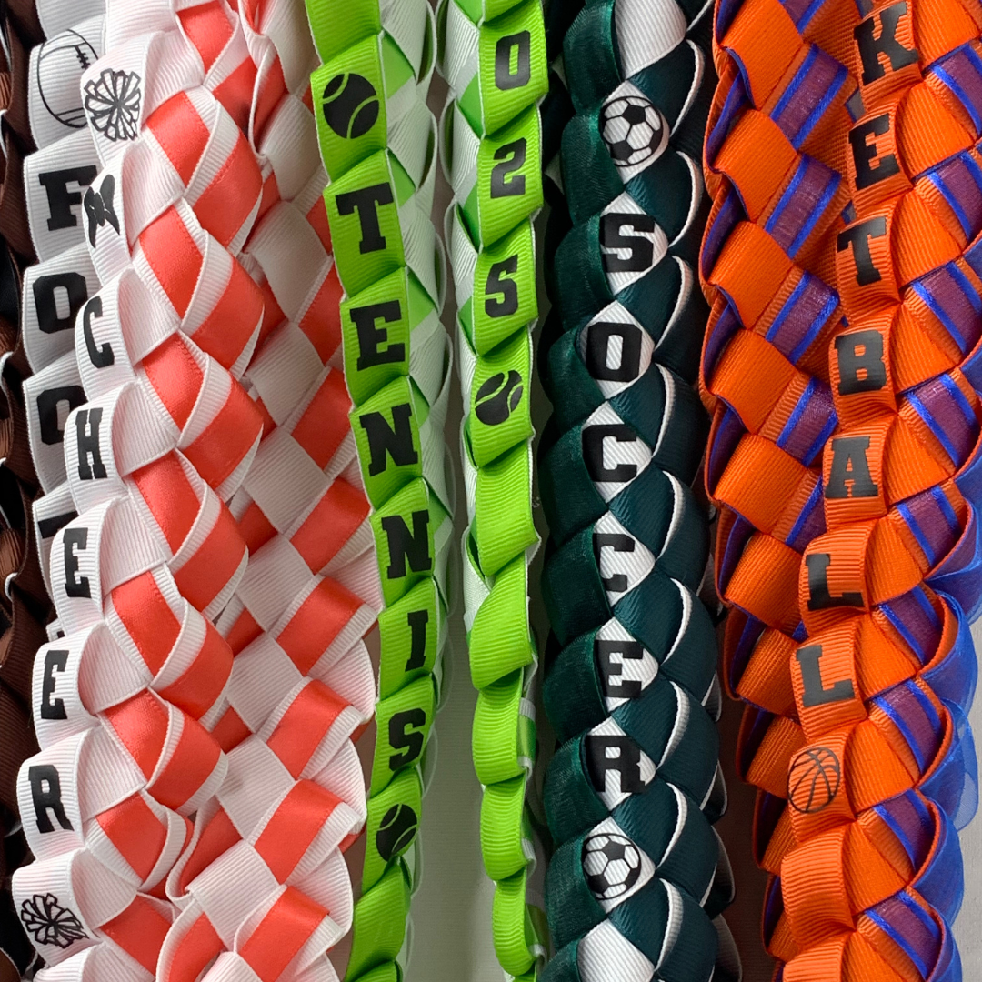 Personalized sports graduation lei featuring colorful braided school ribbons with custom lettering and sports-themed decorations.