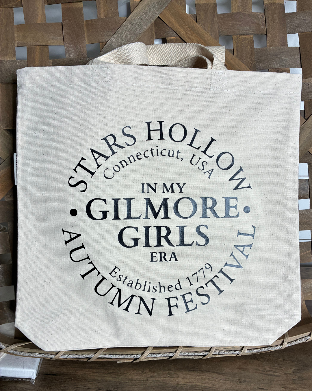 Tote bag with Stars Hollow Gilmore Girls text on a woven surface