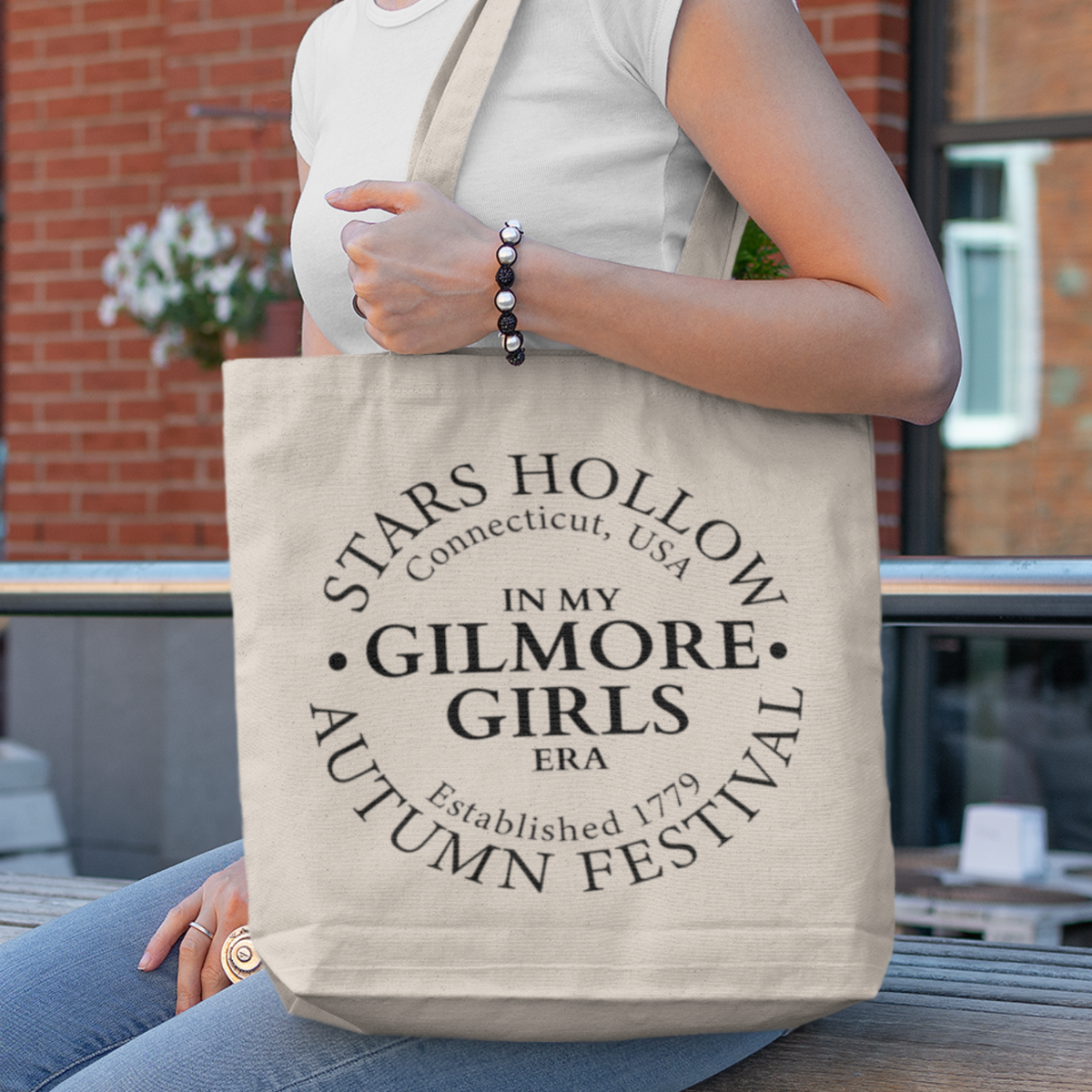 Woman carrying Stars Hollow Tote Bag with In My Gilmore Girls Era autumn festival graphic
