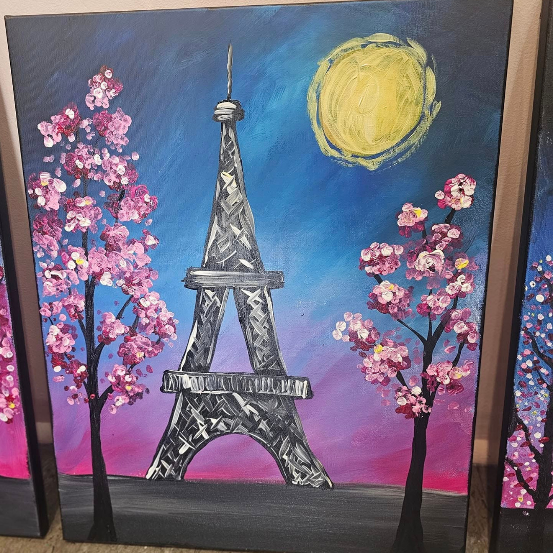 Finished Painting of the Eiffel Tower with cherry blossom trees and a sun in the background from the Summer In Paris DIY Paint Kit collection