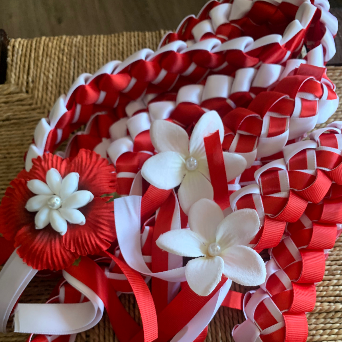 Teacher Appreciation Lei close up featuring handcrafted red and white braided ribbons with floral accents, displayed as a school staff thank-you gift.