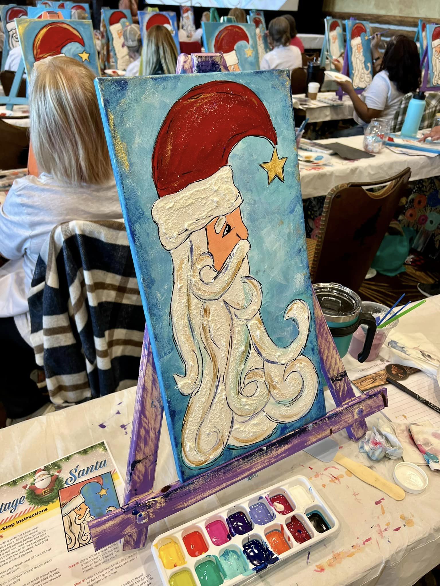  A photo of a Vintage-style Santa Claus with red coat and rosy cheek at a paint party birthday event 