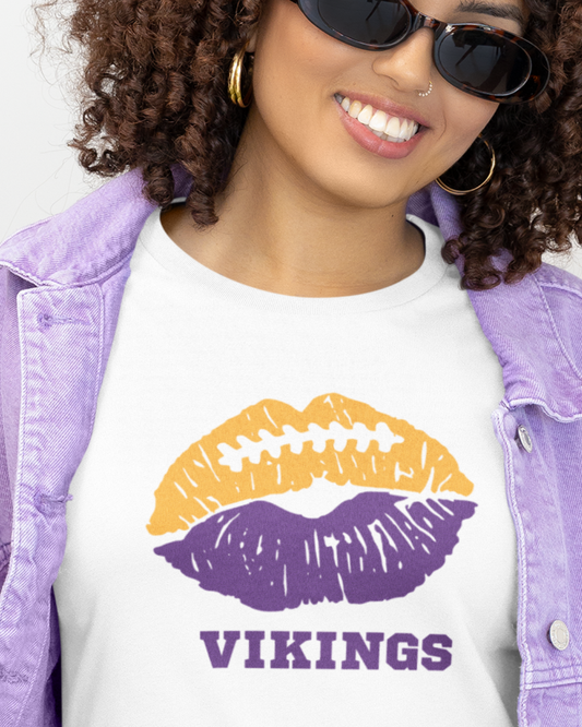 Woman wearing a sand women's football game day T-shirt featuring a blue football lips graphic.