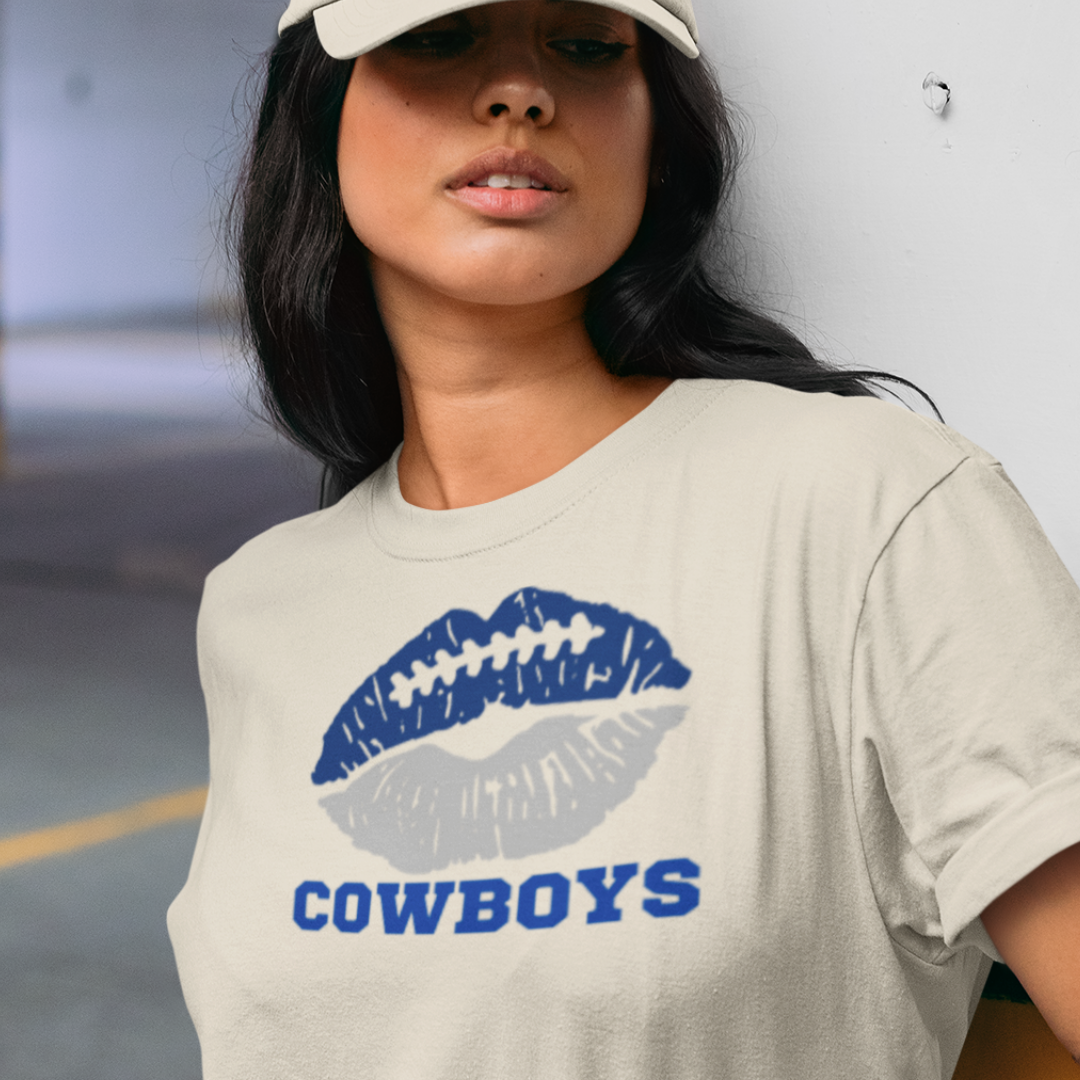 A woman wearing a cream t-shirt with a lip-themed football design reading Cowboys