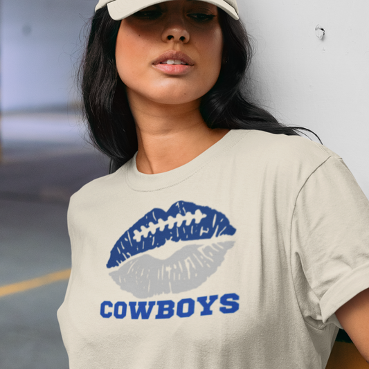 A woman wearing a cream t-shirt with a lip-themed football design reading Cowboys