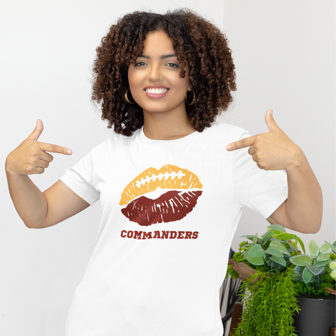 A woman wearing a white t-shirt with a lip-themed football design reading Commanders
